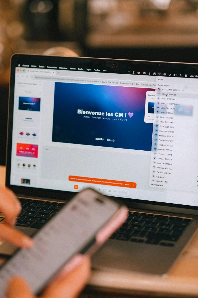 Person using laptop and phone with presentation on-screen presentation.