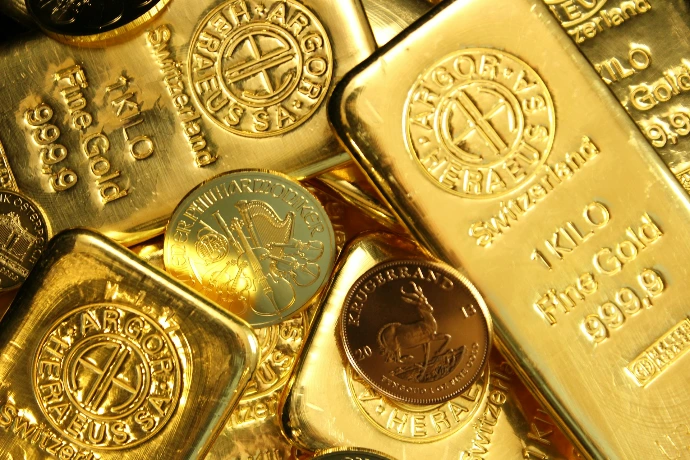 A collection of gold bars and coins with stamped markings and emblems